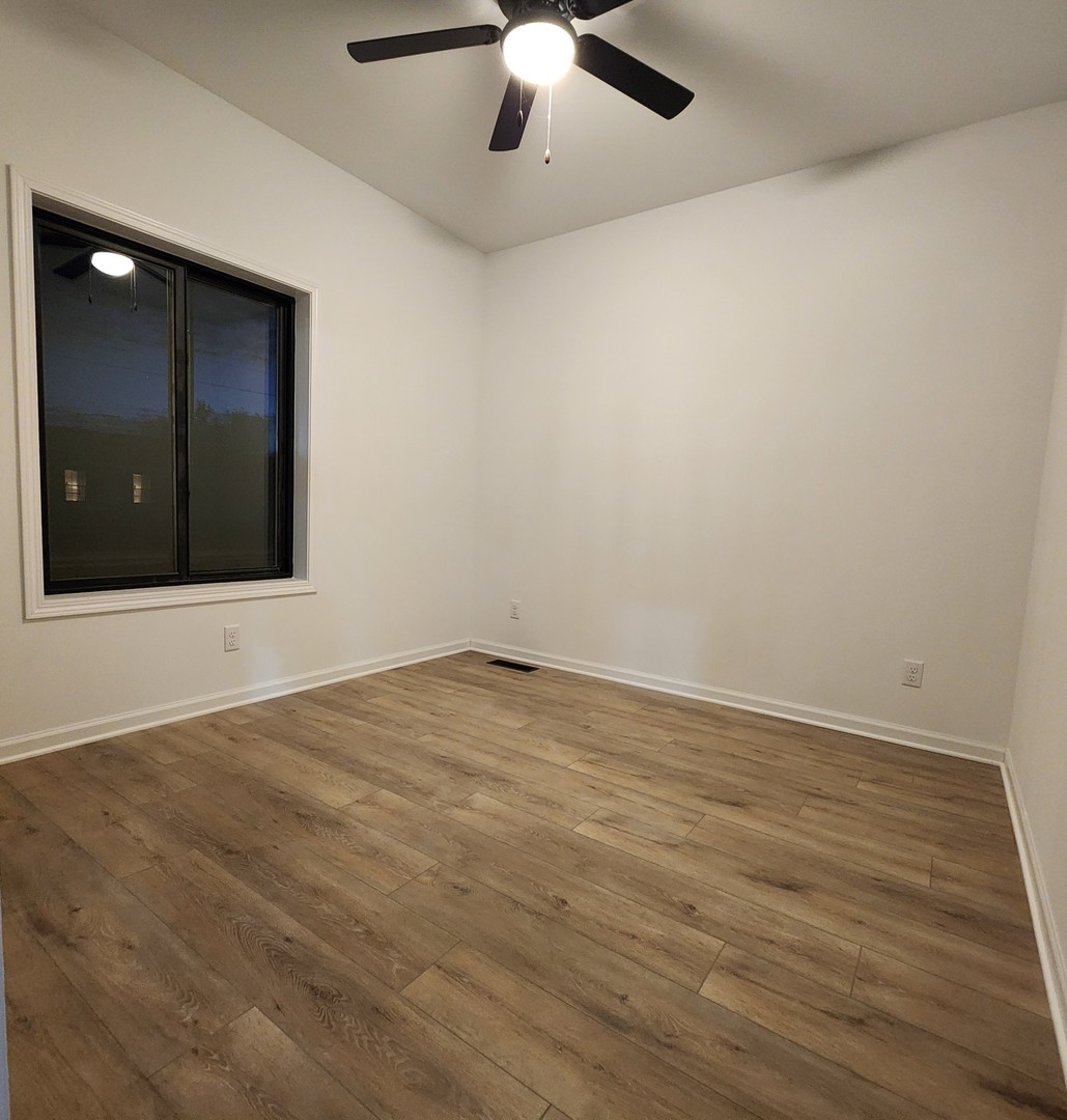 422 View Street Ottawa, IL 61350 - Photo 10 of 22 an empty room with wooden floor and fan
