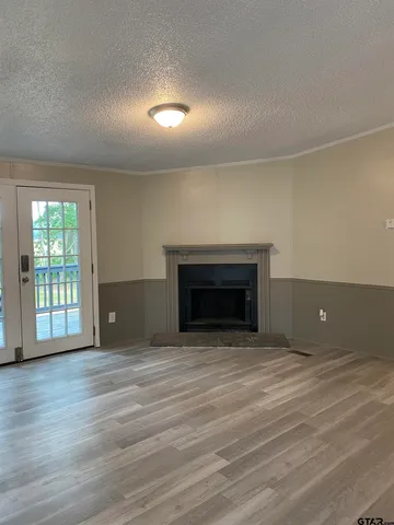 an empty room with wooden floor and fireplace