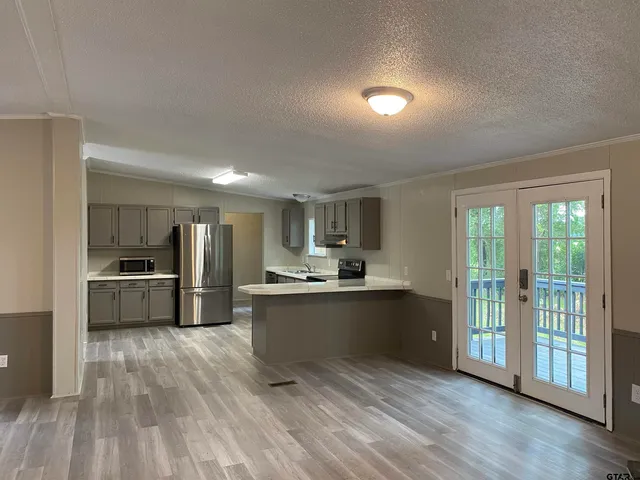 a kitchen with sink a refrigerator and wooden floor