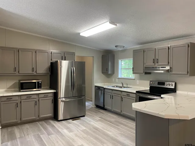 a kitchen with a sink a refrigerator and cabinets