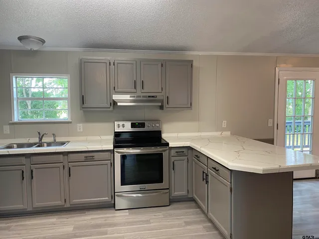 a kitchen with a sink stove and cabinets