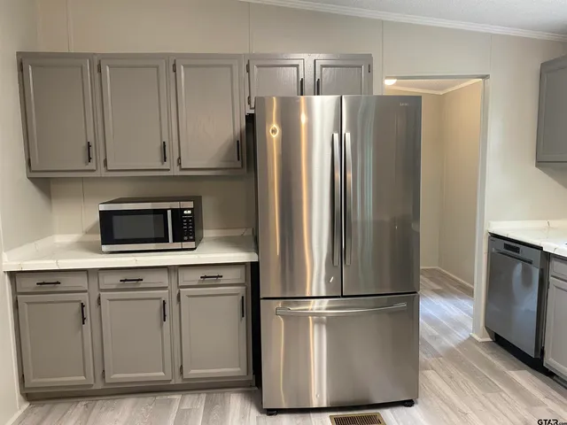 a kitchen with stainless steel appliances a refrigerator sink and microwave