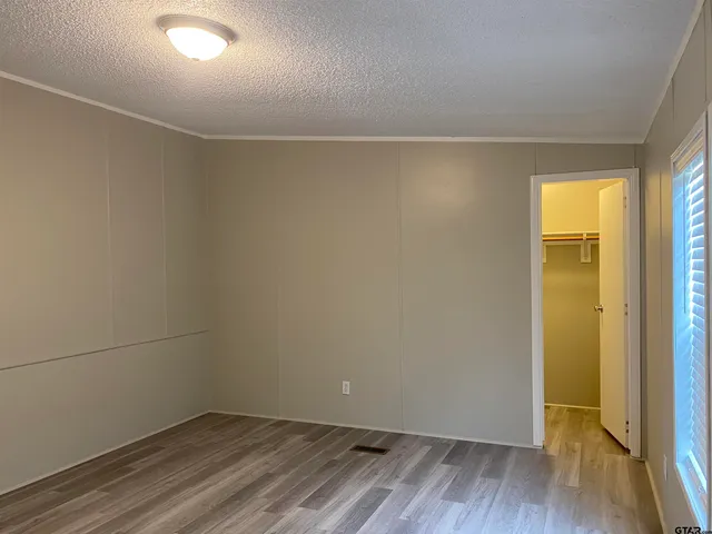 an empty room with wooden floor and closet