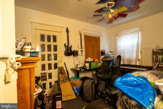 a view of a workspace with furniture and a ceiling fan