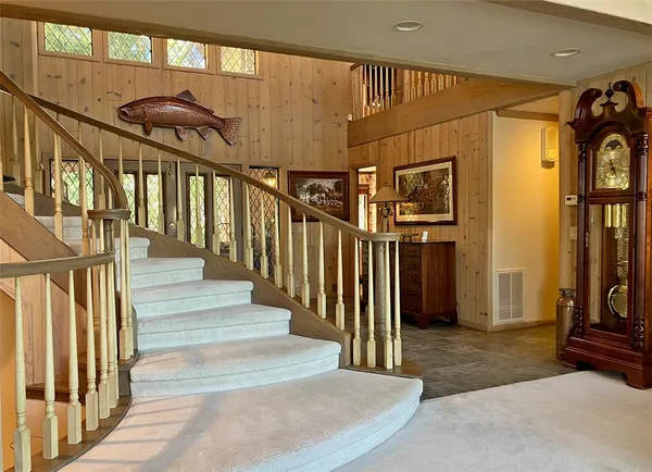 a view of staircase with lots of frames on wall and a chandelier