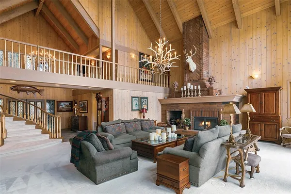 a living room with furniture a fireplace and a large window