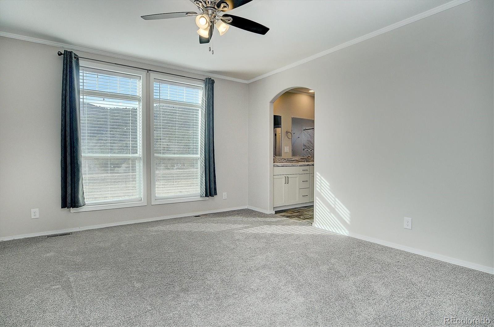 16554 Rocky Mountain Road Salida, CO 81201 - Photo 21 of 33 an empty room with chandelier fan and windows
