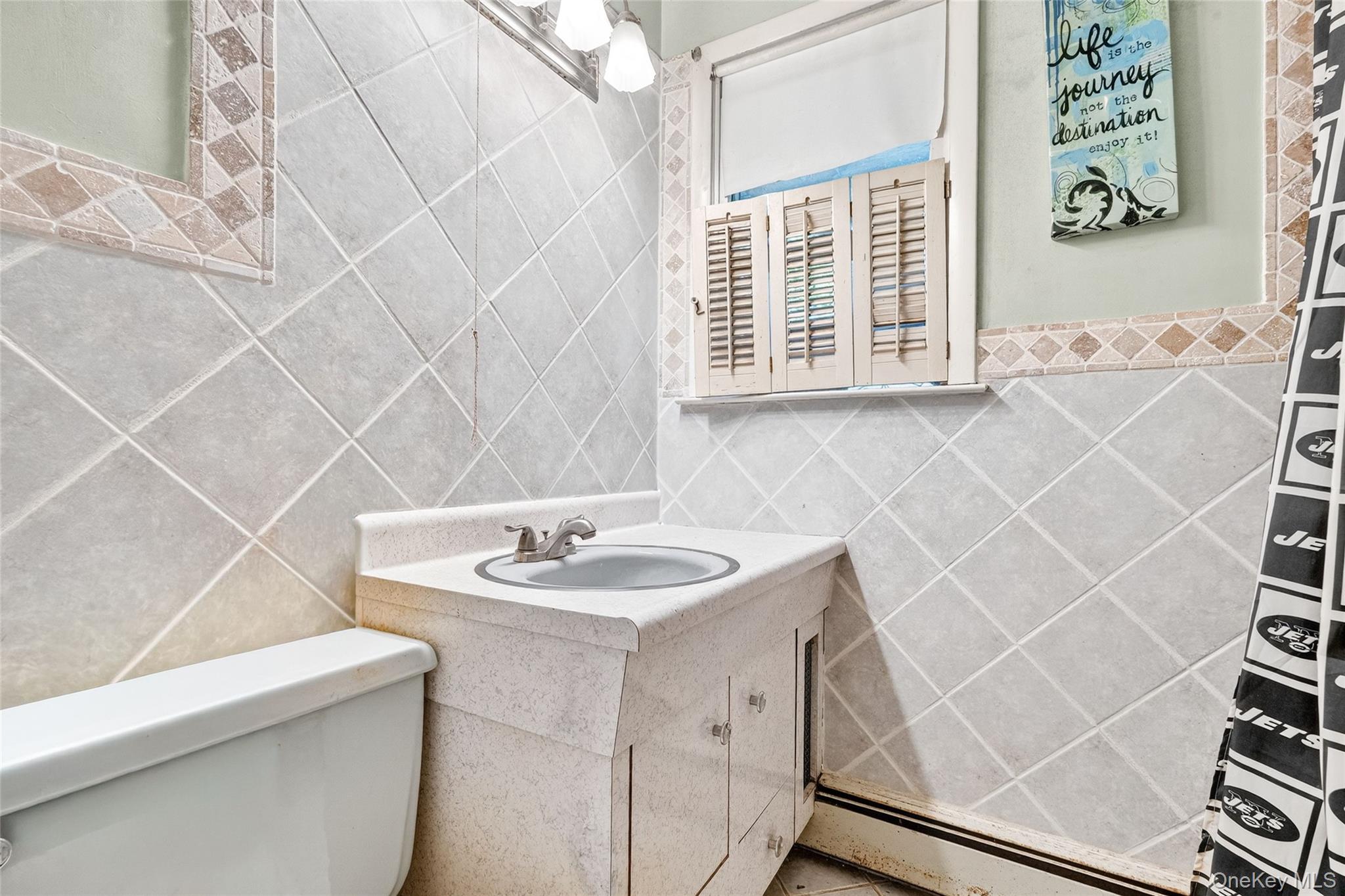25 Russell Road Newburgh, NY 12550 - Photo 31 of 39 Bathroom with vanity, tile walls, and a baseboard heating unit