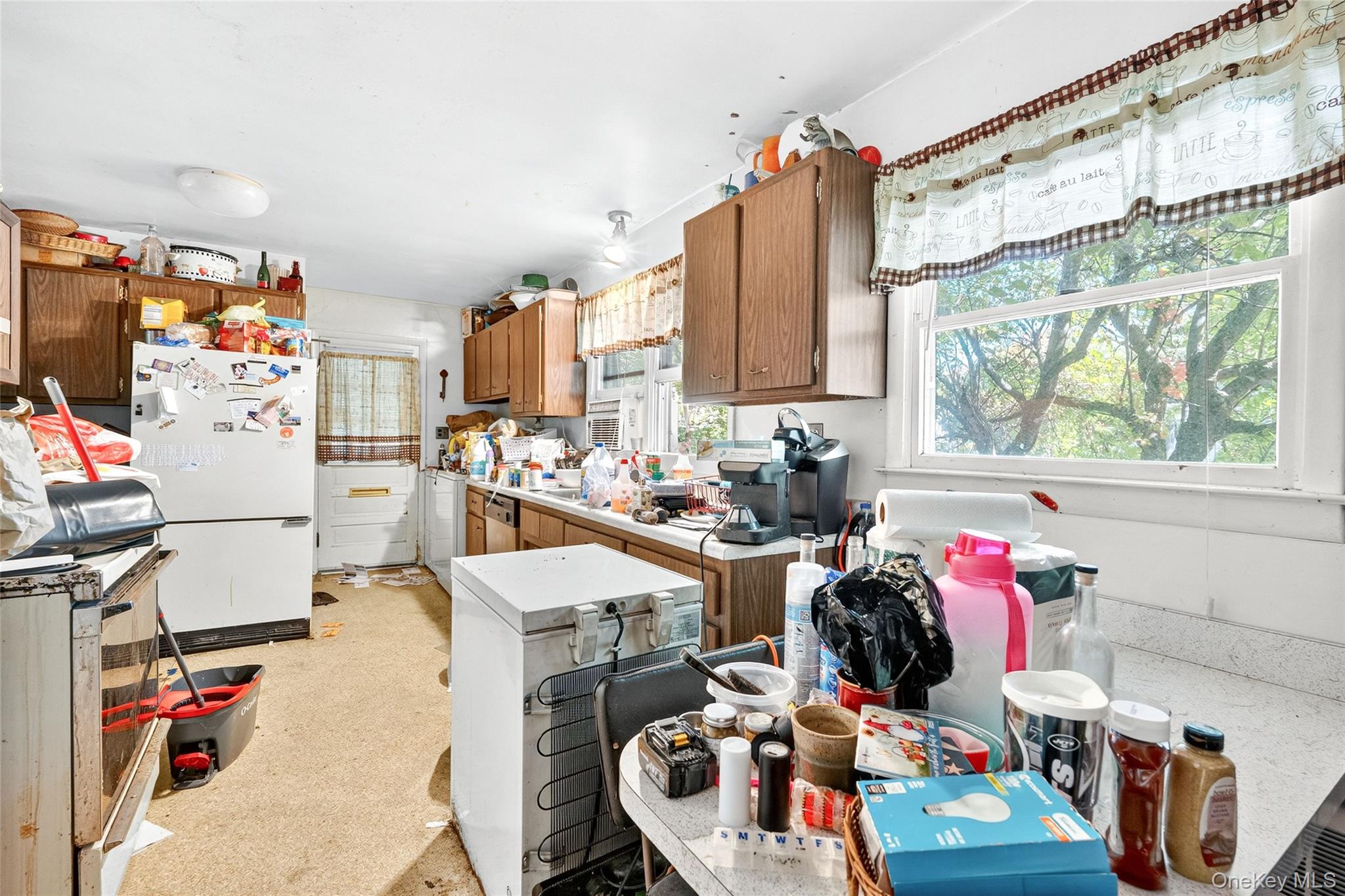 25 Russell Road Newburgh, NY 12550 - Photo 7 of 39 Kitchen featuring freestanding refrigerator, brown cabinets, light countertops, white refrigerator, and range