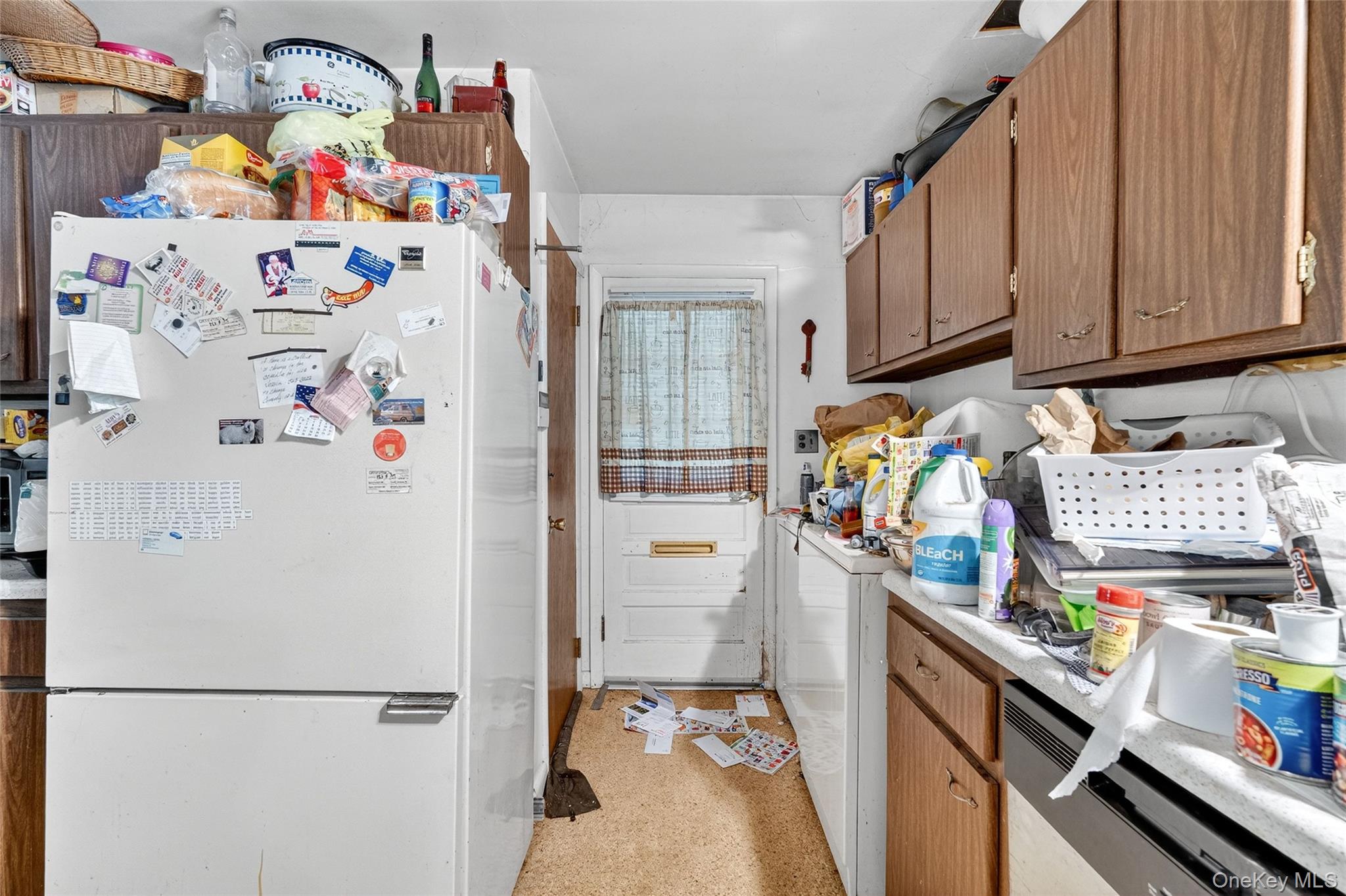 25 Russell Road Newburgh, NY 12550 - Photo 10 of 39 Kitchen featuring freestanding refrigerator, light countertops, brown cabinets, stainless steel dishwasher, and dark aggregate flooring