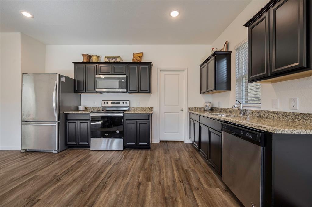 801 Peach Tree Lane Anna, TX 75409 - Photo 6 of 14 a kitchen with granite countertop a refrigerator stove top oven and sink