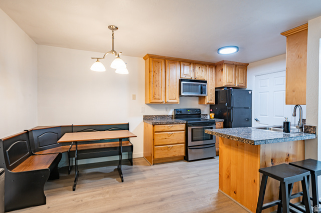 1221 Waterside Cove, Unit 11 Midvale, UT 84047 - Photo 5 of 23 Kitchen featuring wood-finish cabinetry and gray granite-finish countertops