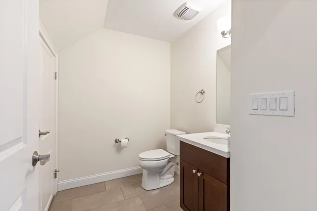 a bathroom with a granite countertop toilet a sink and a mirror