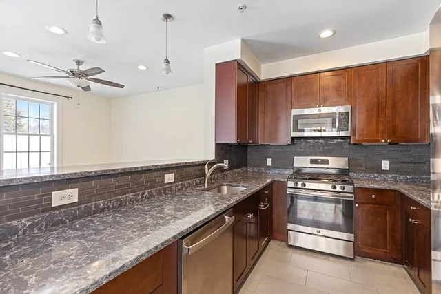 a kitchen with stainless steel appliances granite countertop a sink stove and microwave