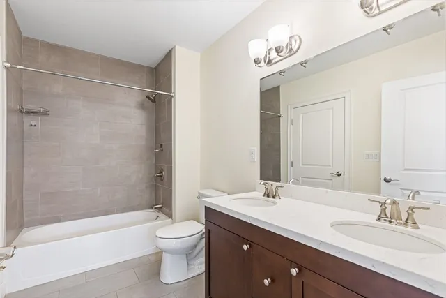 a bathroom with a granite countertop sink toilet a large mirror a bathtub and shower