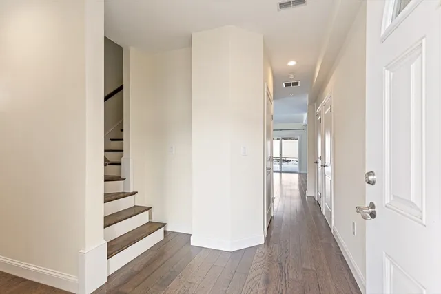 a view of a hallway with wooden floor and entryway