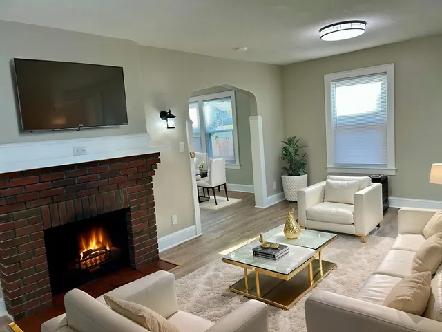a living room with furniture a fireplace and a flat screen tv