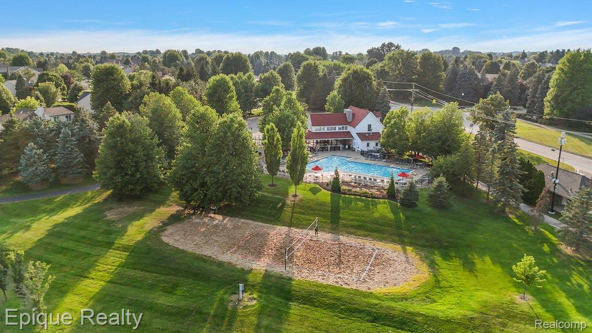 1909 Catlin Drive Rochester, MI 48306 - Photo 67 of 76 Community amenities featuring a central clubhouse with a red roof, a swimming pool, and a sand volleyball court