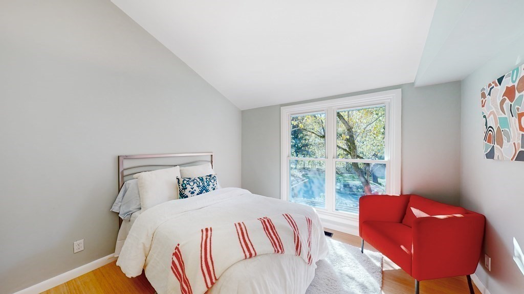 12 Ellis Road Weston, MA 02493 - Photo 15 of 42 a bedroom with a bed and a couch with exposed radiator