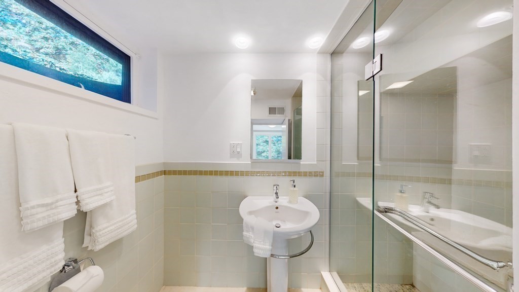 12 Ellis Road Weston, MA 02493 - Photo 22 of 42 a bathroom with a sink mirror and shower