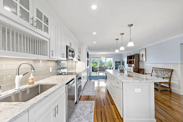 a kitchen with stainless steel appliances kitchen island granite countertop a sink stove and cabinets