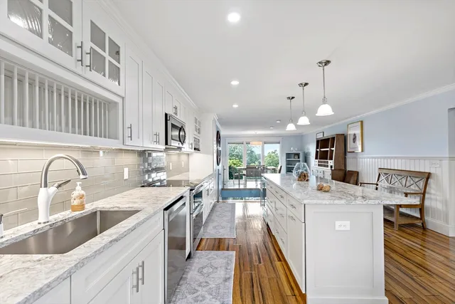 a kitchen with stainless steel appliances kitchen island granite countertop a sink stove and cabinets