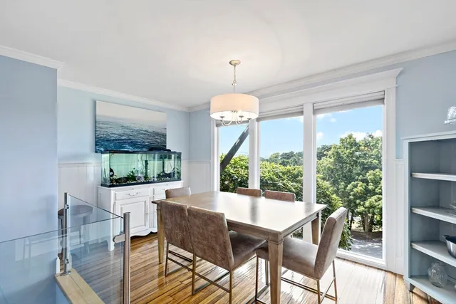 a dining room with furniture a chandelier and wooden floor
