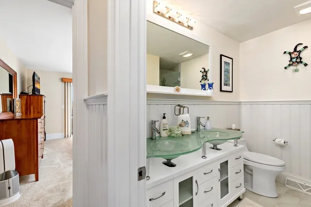 a bathroom with a granite countertop sink a toilet and a mirror