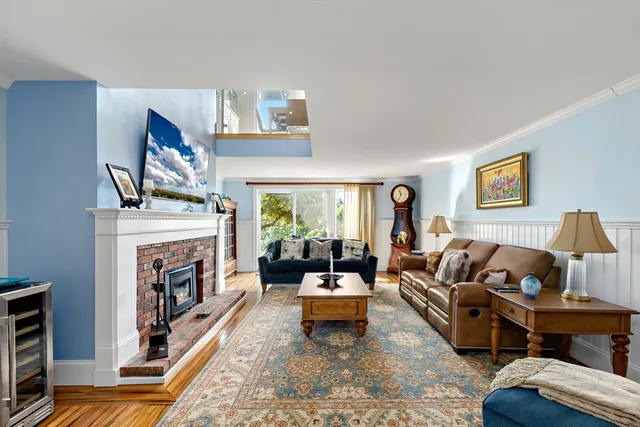 a living room with furniture fireplace and a large window