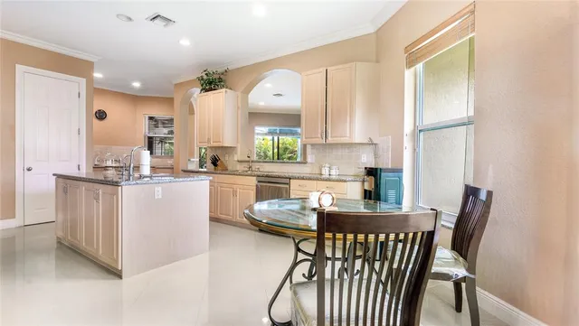 a kitchen with kitchen island a large counter top space appliances and a window