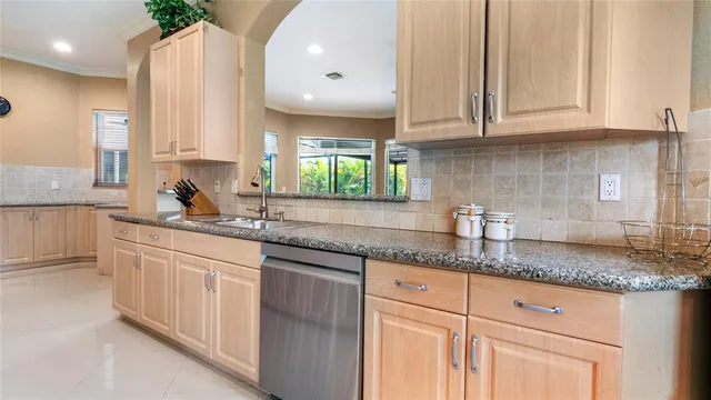 a kitchen with granite countertop white cabinets white appliances and a sink
