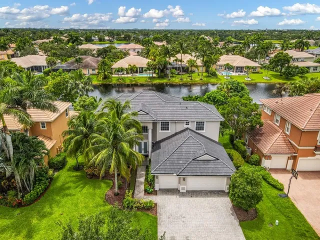 an aerial view of residential houses with outdoor space and a lake view