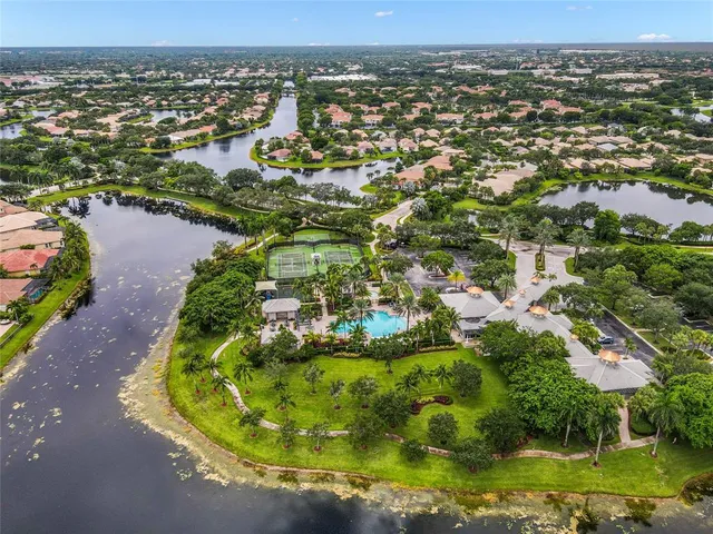 an aerial view of residential houses with outdoor space and trees