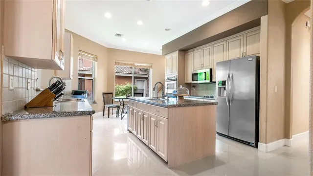 a kitchen with stainless steel appliances granite countertop a refrigerator a stove and a sink