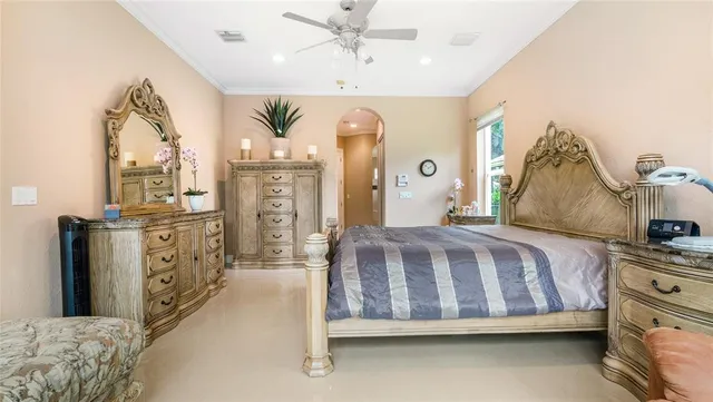 a spacious bedroom with a bed a dresser and potted plants