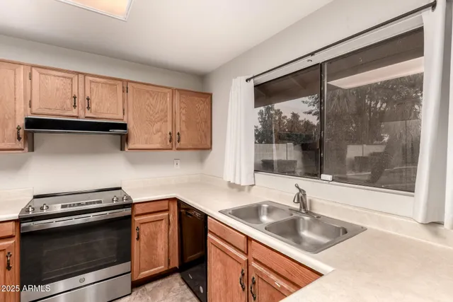a kitchen with granite countertop a sink stove and cabinets