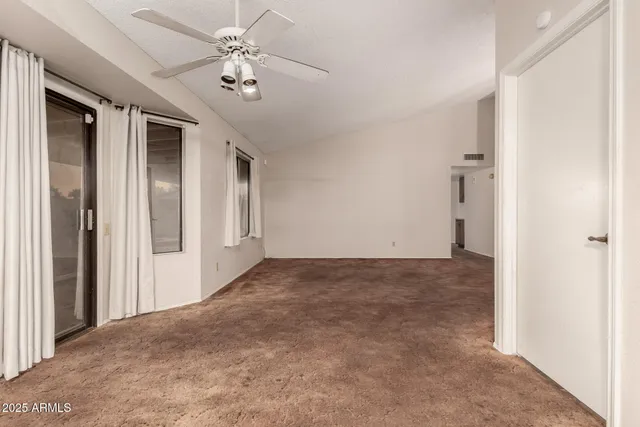 a view of a hallway with a chandelier fan and windows