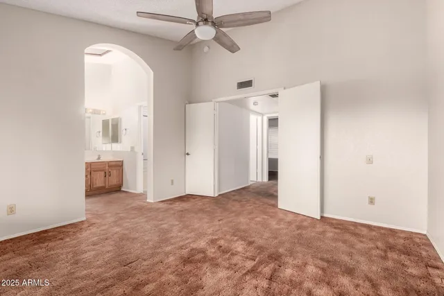 a view of a big room with closet and a chandelier fan