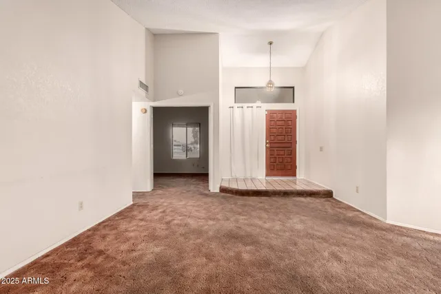 a view of a room with an empty space and window