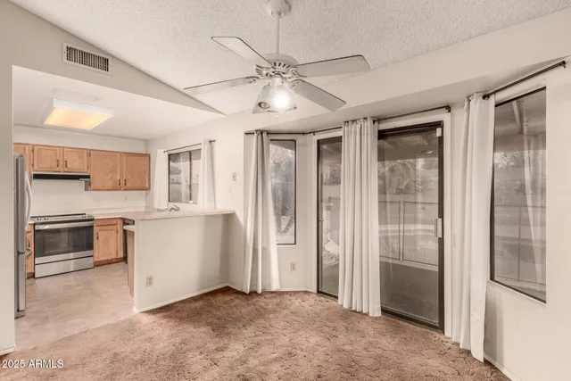 a view of a kitchen with a sink and dishwasher a refrigerator with white cabinets
