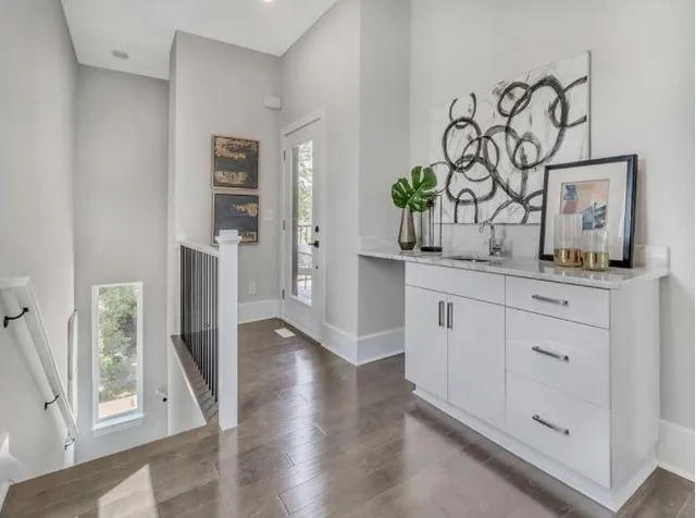 a kitchen with white cabinets and wooden floor
