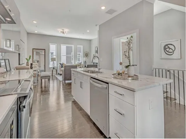 a large white kitchen with lots of counter space a sink and appliances