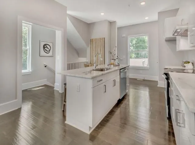 a large white kitchen with a stove top oven