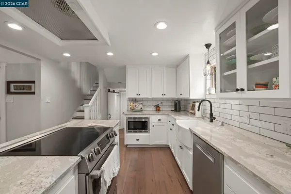 a kitchen with a sink stove top oven and cabinets