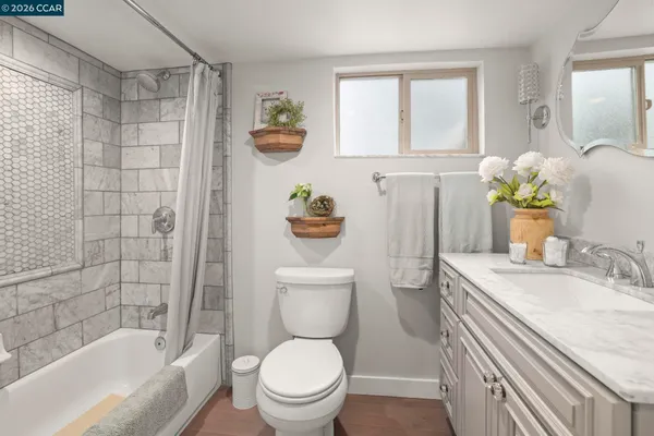 a bathroom with a granite countertop sink a toilet and shower