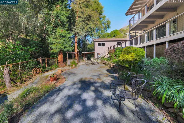 a view of backyard with a table and chairs and potted plants