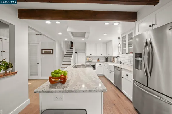 a kitchen with stainless steel appliances granite countertop a refrigerator and a sink