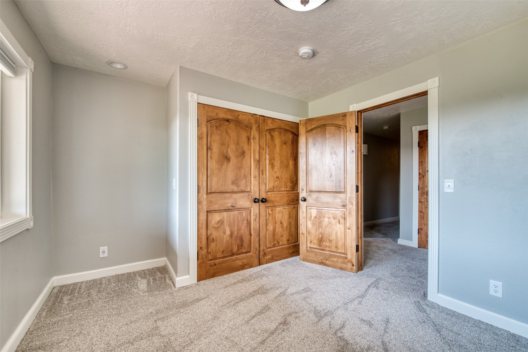 16374 Folsom Road Florence, MT 59833 - Photo 91 of 98 Unfurnished bedroom with carpet floors, a textured ceiling, and a closet