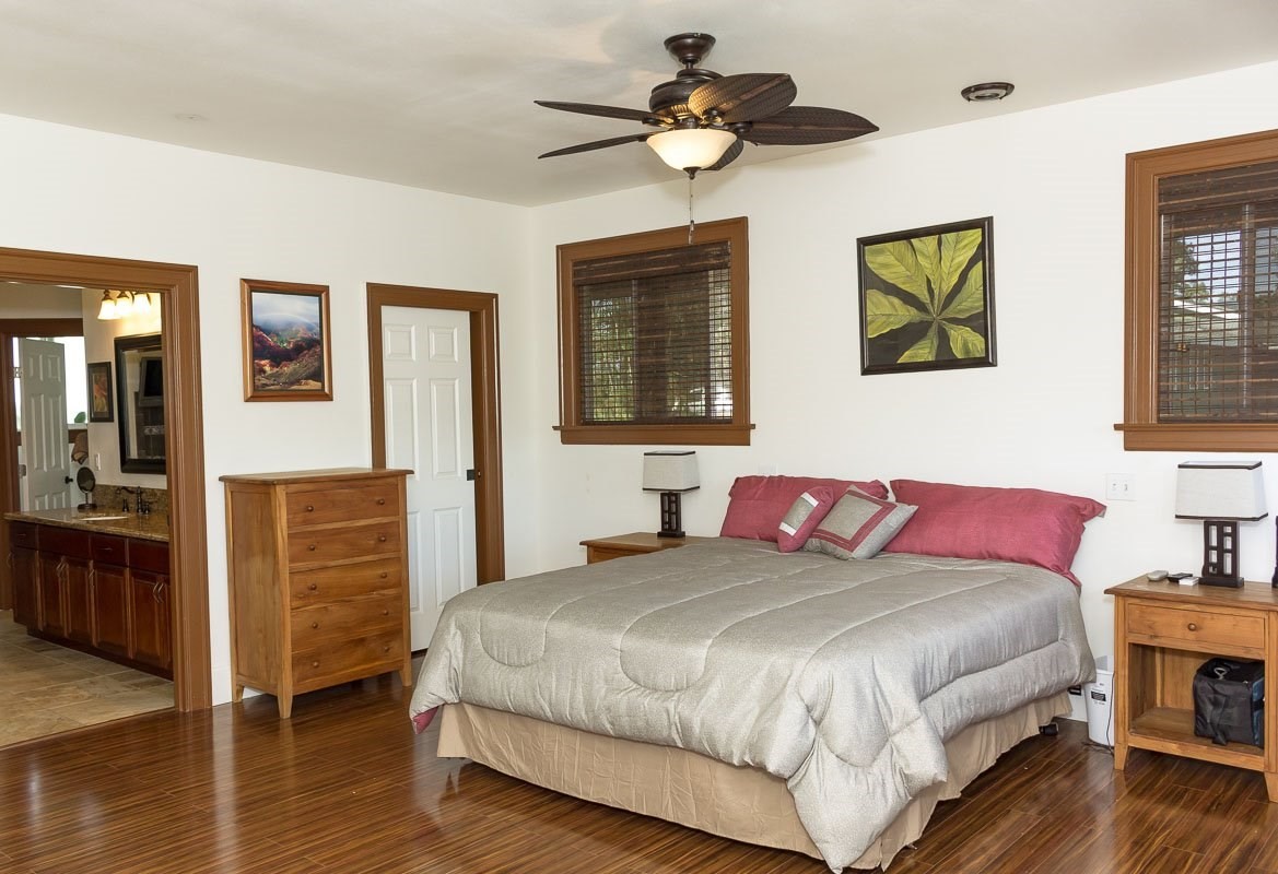 3746 Omao Road Koloa, HI 96756 - Photo 12 of 25 a bedroom with a bed and wooden floor