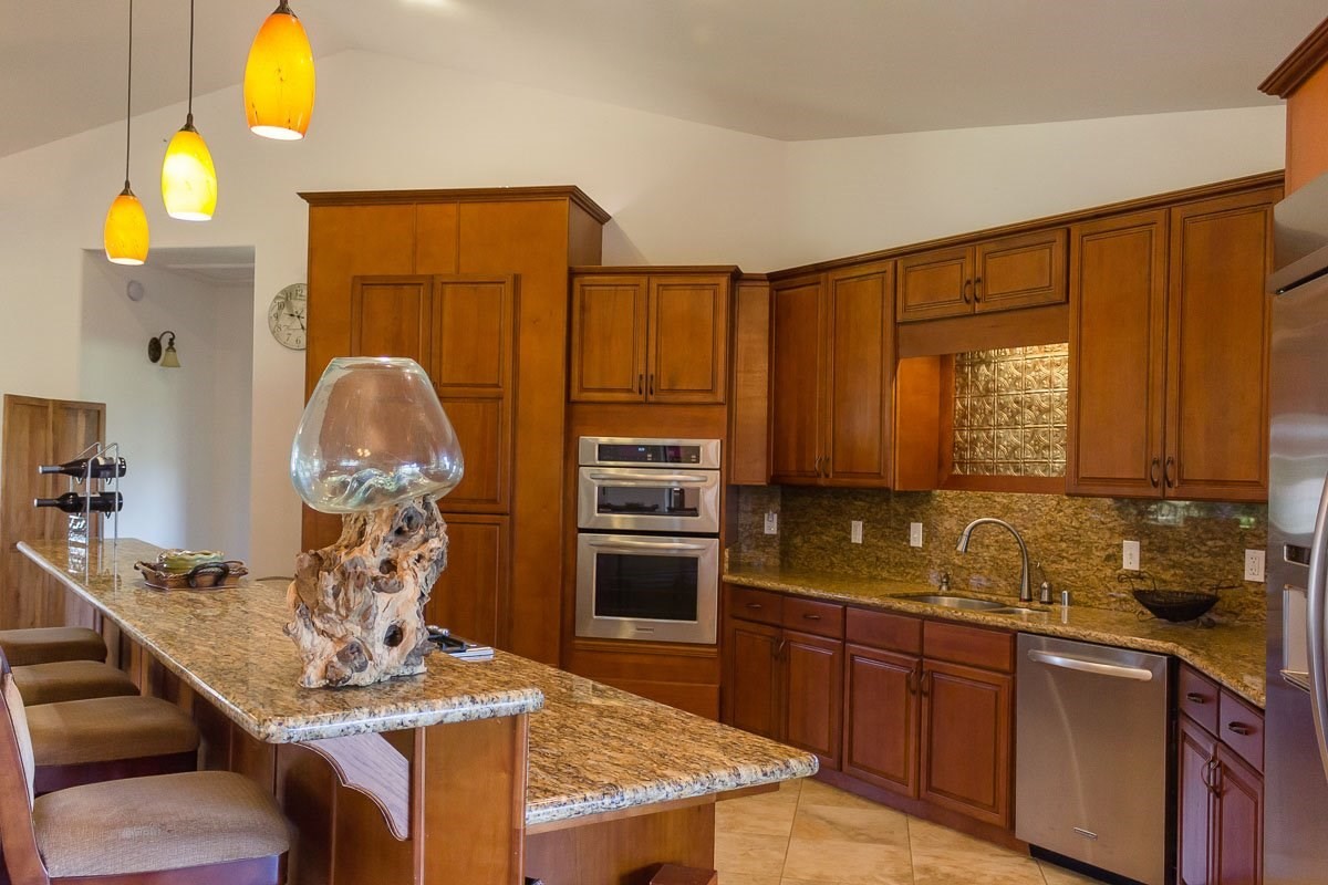 3746 Omao Road Koloa, HI 96756 - Photo 8 of 25 a kitchen with stainless steel appliances granite countertop a stove refrigerator and cabinets